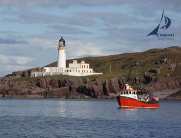 Rotes Schiff vor Leuchtfeuer